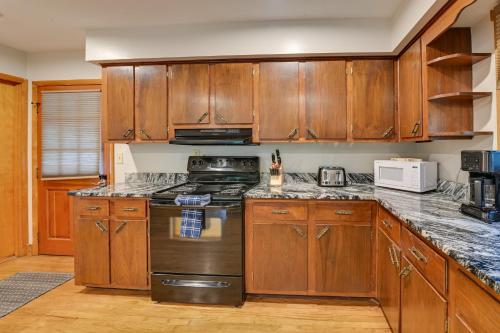 a kitchen with wooden cabinets and a stove top oven at Red River Gorge Cabin Hike and Relax! in Rogers