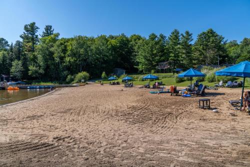 a beach with blue umbrellas and people on it at Blue Water Acres in Huntsville
