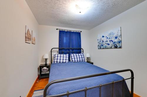 a bedroom with a bed with a blue blanket at Cabin Getaway Near Red River Gorge Recreation in Rogers