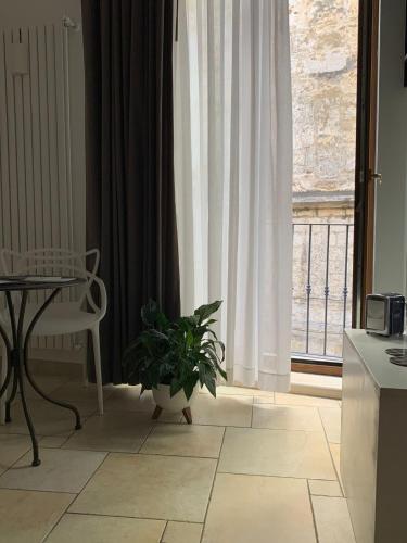 a kitchen with a table and a plant in front of a window at Il Moretto in Trani