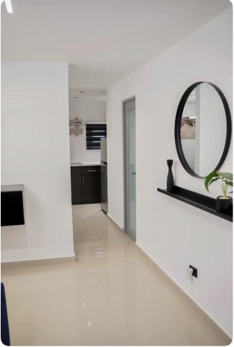 a white room with a mirror and a white floor at North Breeze Guest House 3 in Toa Baja