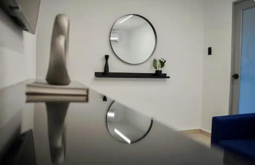 a mirror on a white wall in a room at North Breeze Guest House 3 in Toa Baja