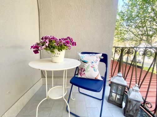 a table and a chair with a vase of flowers on a balcony at Hotel Praja Mare in Praia a Mare