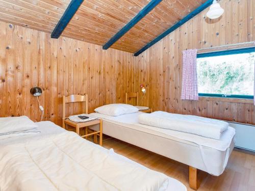 two beds in a room with wooden walls at 7 person holiday home in Lemvig-By Traum in Lemvig