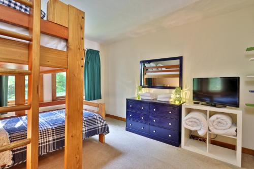 a bedroom with two bunk beds and a television at Sunrise Timberline M1- Cozy 2 BR Ski On Ski Off Condo in Killington