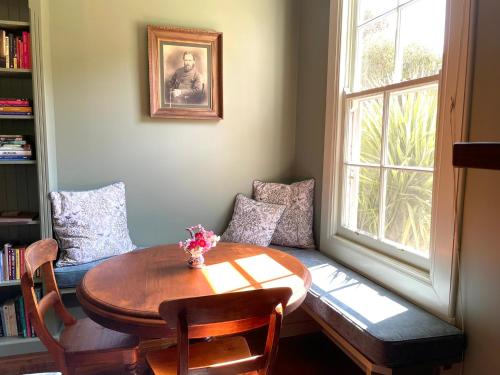 a living room with a table and a couch and a window at The Reverie - a place to rest in Kyneton