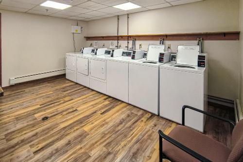 a laundry room with a row of washers and dryers at Pico Mountain Perch, Unit B22 in Mendon