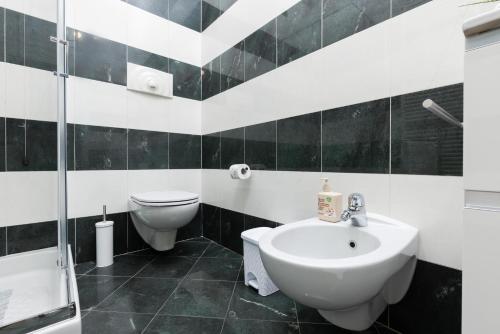a black and white bathroom with a sink and a toilet at Casa Sancarlino - 200mt Clinica Zucchi in Monza