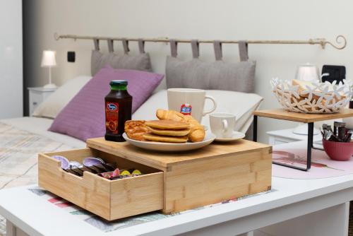a wooden tray with a plate of pastries and a bottle of beer at Casa Sancarlino - 200mt Clinica Zucchi in Monza