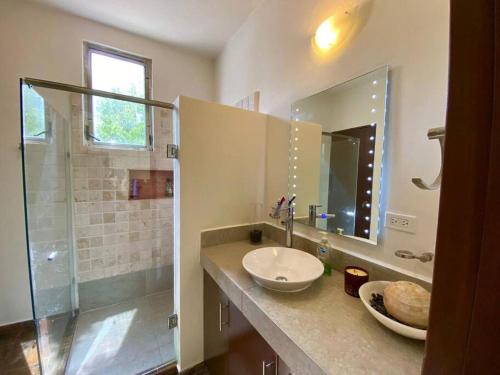 a bathroom with a sink and a shower at Casa Escondida in Isla Mujeres