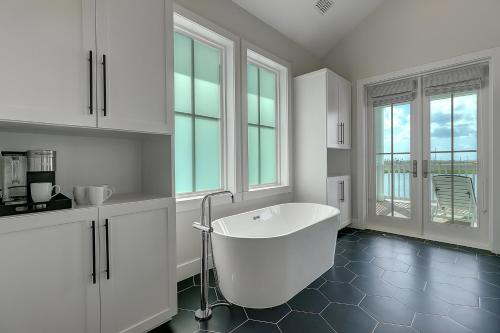 a large white bathroom with a tub and windows at Keepin' It Reel 234 LAK in Port Aransas