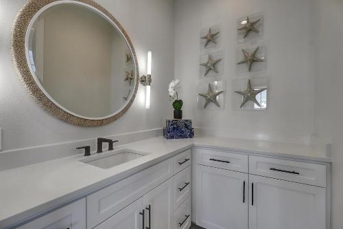 a white bathroom with a sink and a mirror at Keepin' It Reel 234 LAK in Port Aransas