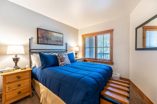 a bedroom with a bed with blue sheets and a window at Expedition Station 8598 in Keystone