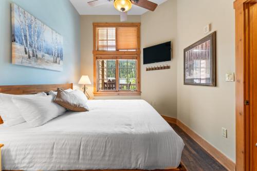 une chambre avec un grand lit blanc et une fenêtre dans l'établissement Expedition Station 8631 by Summit County Mountain Retreats, à Keystone