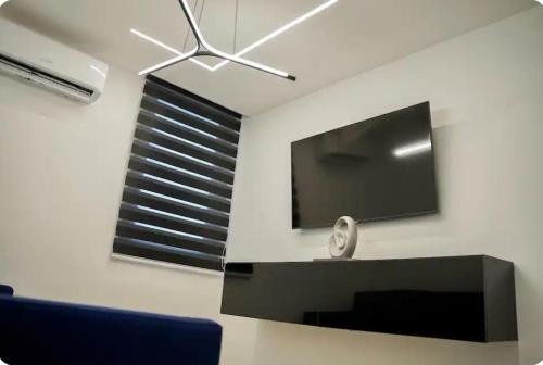 a living room with a flat screen tv on a wall at North Breeze Guest House 3 in Toa Baja