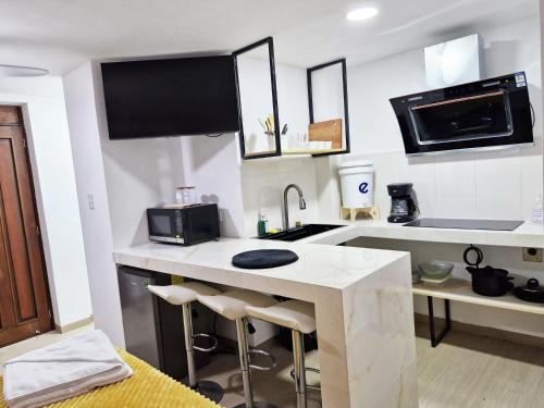 a white kitchen with a sink and a microwave at Moderno y Confortable Apto 4 Familiar Primer Nivel in El Rodeo