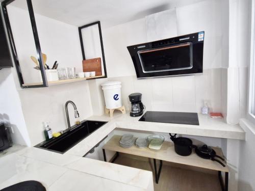 a white kitchen with a sink and a microwave at Moderno y Confortable Apto 4 Familiar Primer Nivel in El Rodeo