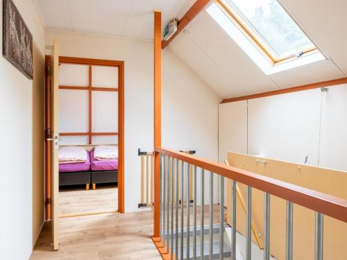 a room with a skylight and a staircase with a bed at Zonnehoek in Exloo