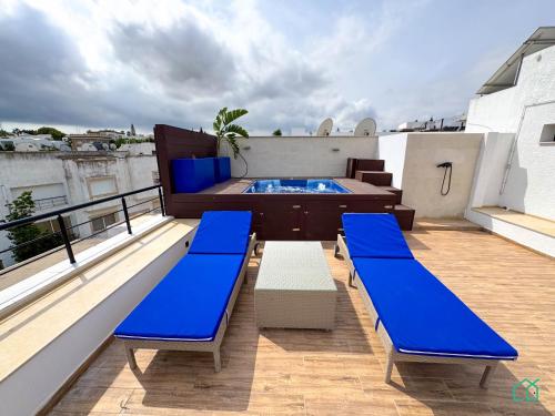 a balcony with two blue benches and a swimming pool at The Penthouse Gammarth in Gammarth