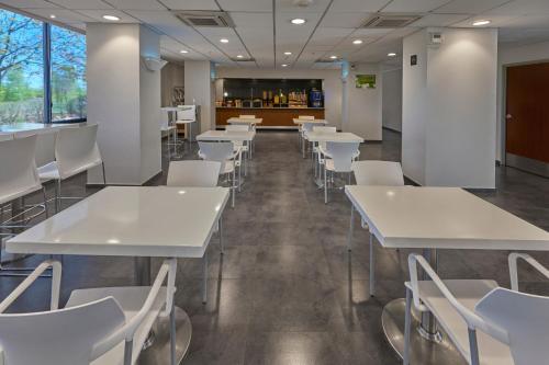 a dining room with white tables and white chairs at City Express by Marriott Tijuana Insurgentes in Tijuana