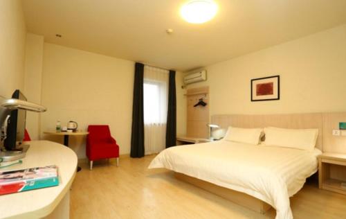 a bedroom with a white bed and a red chair at Jinjiang Inn - Changchun Convention & Exhibition Center in Changchun