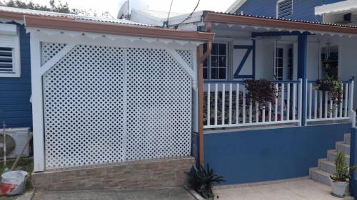 a blue house with a white lattice gate at Les Gîtes SUN AND SEA in Deshaies