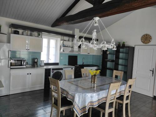 - une cuisine avec une table à manger et des chaises dans l'établissement Maison rénovée à la ferme avec jardin privé, WI-FI, pêche, balançoire, trampoline - Brem-sur-Mer - FR-1-426-103, à Brem-sur-Mer
