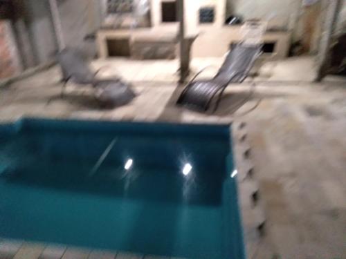 a view of a swimming pool with two benches at Pousada mirante por do sol in Niterói