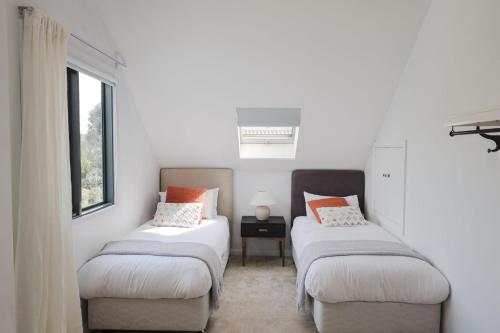Clarence PointにあるChateau Clarence & Petite Chateau Luxurious Waterfront Retreatの窓のある部屋にツインベッドが2台