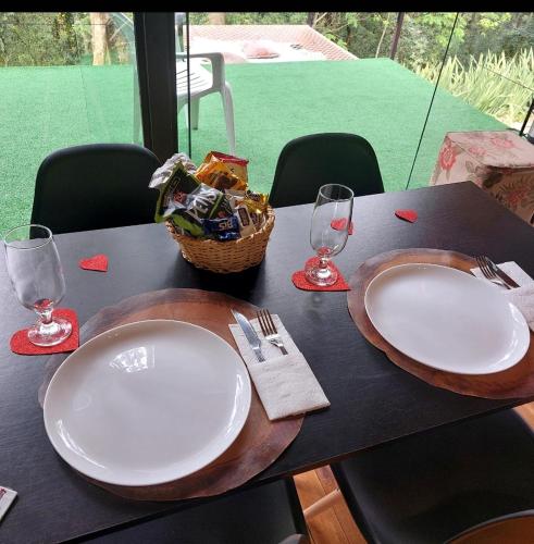 a table with two white plates and a basket of food at Cabana Das Paineiras in Feliz