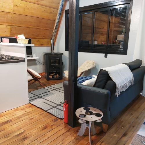 a living room with a couch and a stove at Cabana Das Paineiras in Feliz