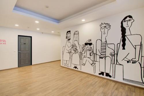 a room with a mural of a group of people at Hotel O Sasti Inn in Pondicherry