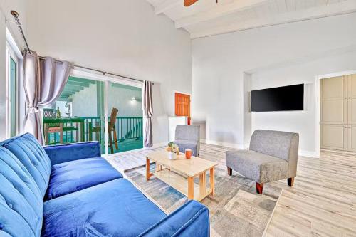 a living room with a blue couch and a table at Balboa Peninsula Hidden Gem with Private Balcony & Stunning Views in Newport Beach