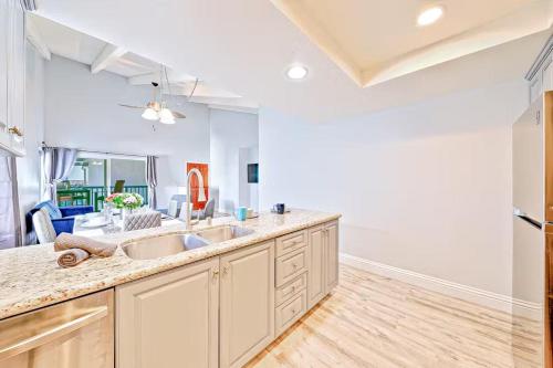 a kitchen with two sinks and a living room at Balboa Peninsula Hidden Gem with Private Balcony & Stunning Views in Newport Beach