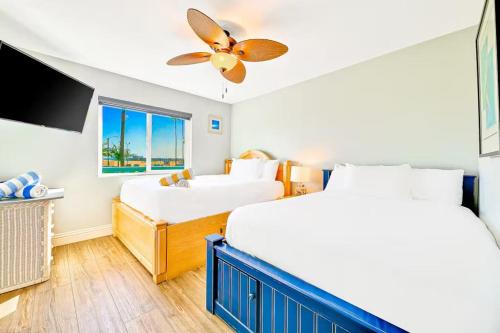 a bedroom with two beds and a flat screen tv at Condo in Newport Beach with Private Balcony and Ideal Location by the Pier in Newport Beach