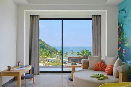 a living room with a couch and a large window at Lampung Marriott Resort & Spa in Lampung