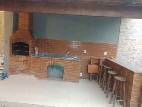 a brick bar with stools in front of a fireplace at Casa Griebeler 02 in Rio de Janeiro