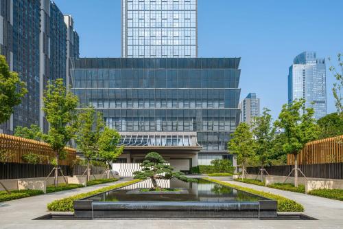 a park in front of a building with a tree in the middle at Luoyang Marriott Hotel in Luoyang
