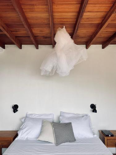 a bedroom with a bed with white sheets and pillows at Refúgio entre Mar e Montanha in Paraty