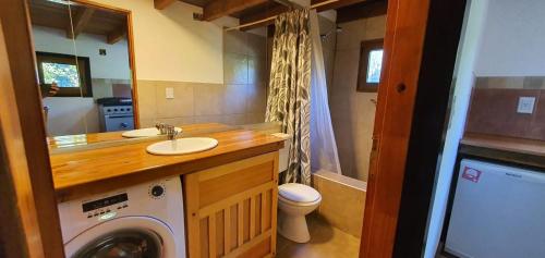 a bathroom with a washing machine and a sink at Casas Huron!! in San Carlos de Bariloche