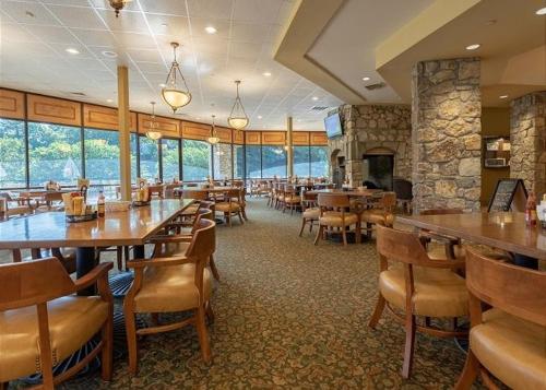 a restaurant with tables and chairs and a fireplace at Lazy JC Lodge lodge in Branson West