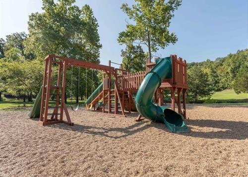 a playground with a slide in a park at Lazy JC Lodge lodge in Branson West