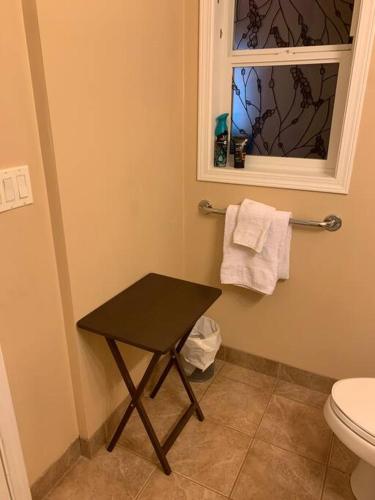 a bathroom with a black table and a toilet at Salish B&B and Spa in West Kelowna
