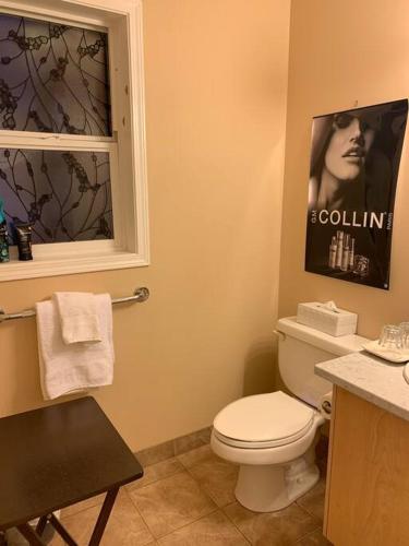 a bathroom with a toilet and a poster of a woman at Salish B&B and Spa in West Kelowna