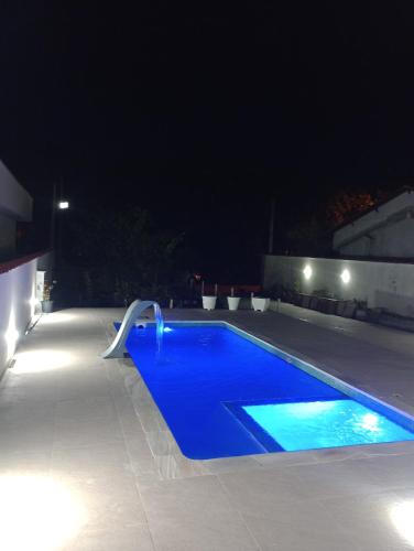 - une piscine bleue la nuit éclairée dans l'établissement Morada da praia, à Bertioga
