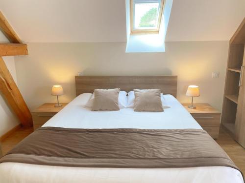 a bedroom with a large white bed with two lamps at Gîte en Val de Loire: confort, jardin, parking et WiFi inclus - FR-1-491-452 in Thésée
