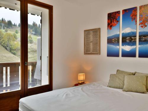 une chambre avec un lit et une grande fenêtre dans l'établissement Confortable appart 6-8 pers au pied des pistes, centre Chinaillon - FR-1-467-131, au Grand-Bornand