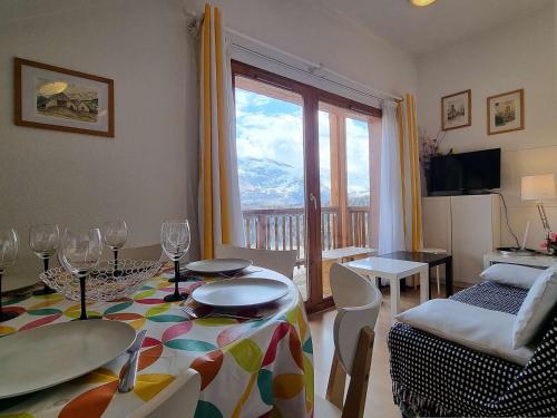 un salon avec une table et des chaises et une fenêtre dans l'établissement Appartement 4 pers à 250m des pistes avec Parking et Balcon - FR-1-525-290, à Superdevoluy
