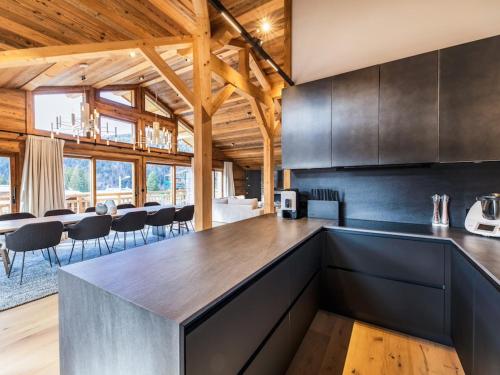 une cuisine avec des comptoirs en acier inoxydable et des plafonds en bois dans l'établissement Chalet de luxe aux Gets avec jacuzzi, sauna, Wi-Fi, parking - FR-1-671-272, aux Gets