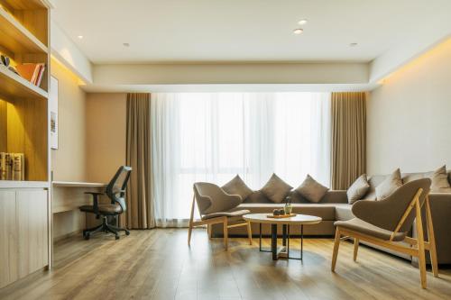 a living room with a couch and chairs and a table at Atour Hotel Hangzhou Binjiang Jiangling Road in Hangzhou